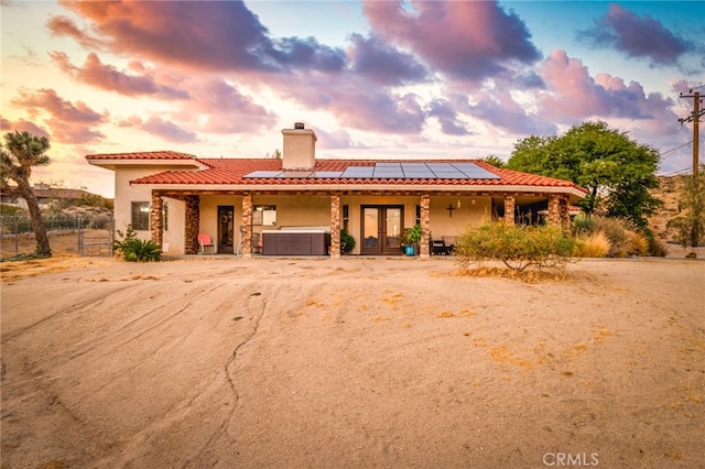 view of front of house featuring a jacuzzi and solar panels