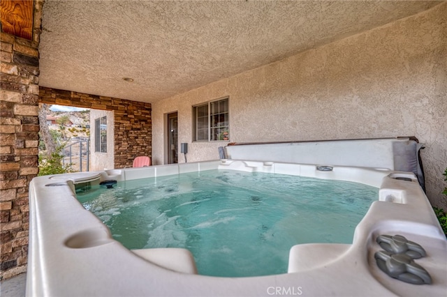 view of swimming pool featuring a hot tub