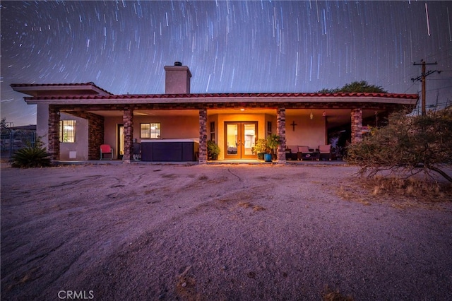 view of front facade with a patio, french doors, and a jacuzzi