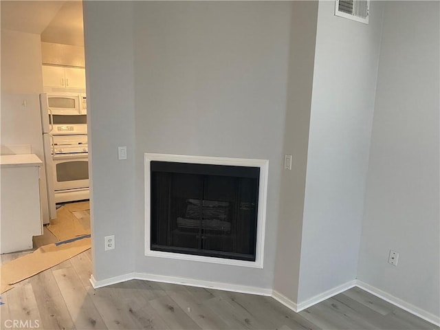 interior details with white appliances and wood-type flooring