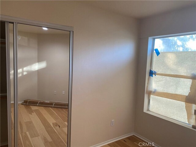 unfurnished bedroom with a closet and light hardwood / wood-style flooring