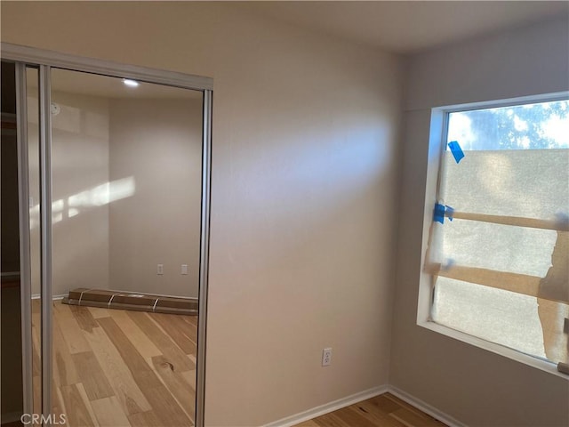 unfurnished bedroom featuring a closet and light wood-type flooring