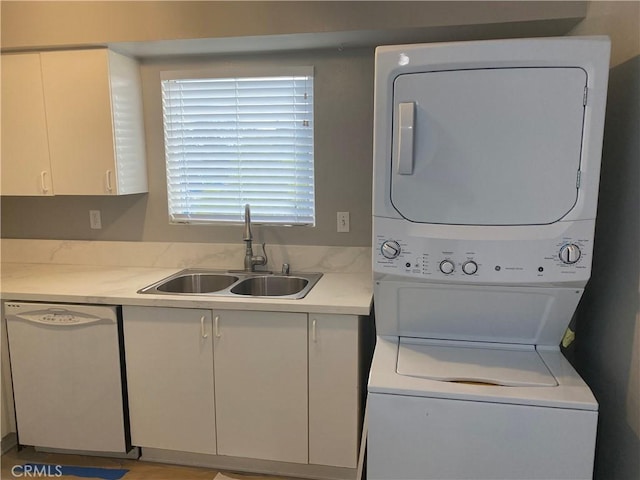 laundry area with sink and stacked washing maching and dryer