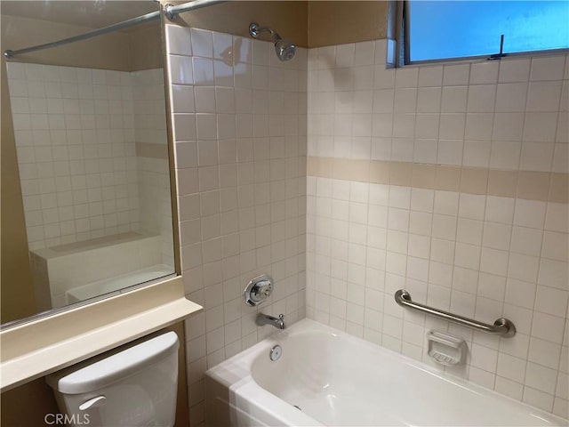 bathroom with tiled shower / bath and toilet