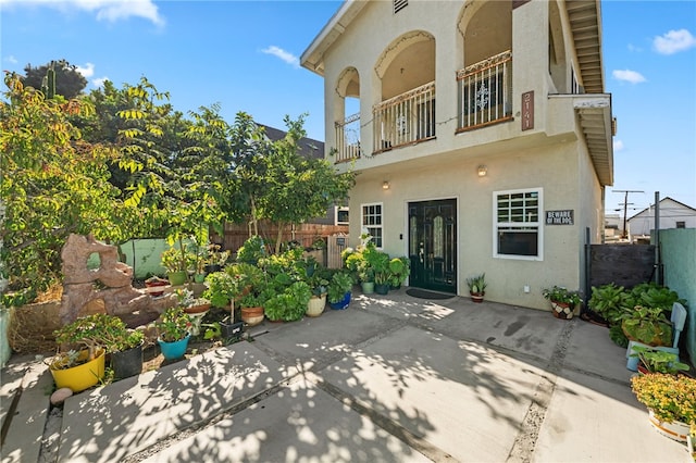 rear view of house with a patio area and a balcony