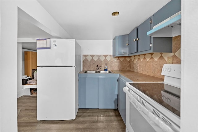 kitchen with white appliances, sink, dark hardwood / wood-style floors, blue cabinetry, and extractor fan