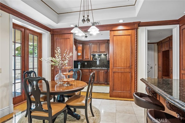 tiled dining area with french doors, a notable chandelier, crown molding, and a tray ceiling