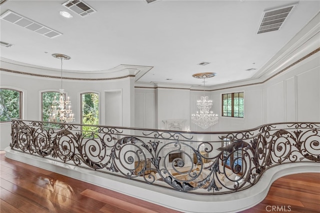 hallway with crown molding, wood-type flooring, and plenty of natural light