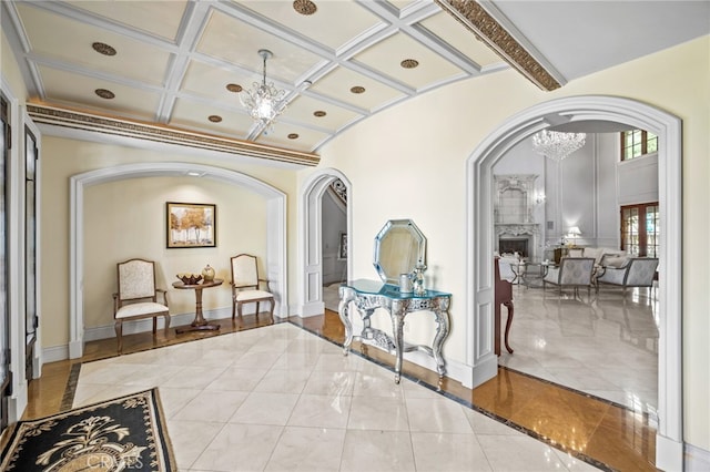 interior space with beam ceiling, a chandelier, and coffered ceiling