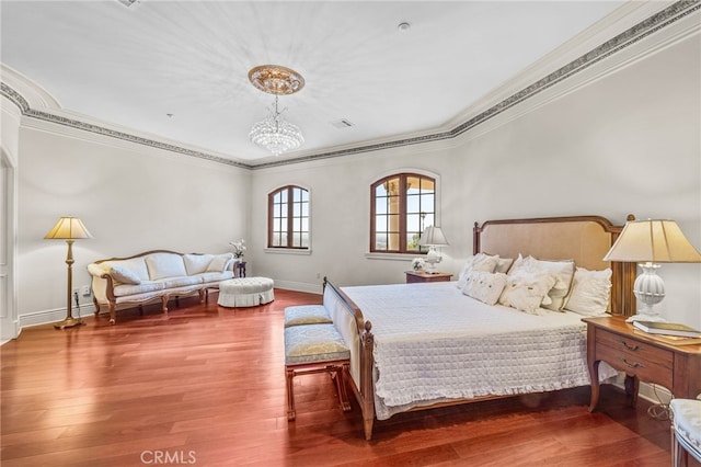 bedroom with ornamental molding, hardwood / wood-style floors, and a notable chandelier