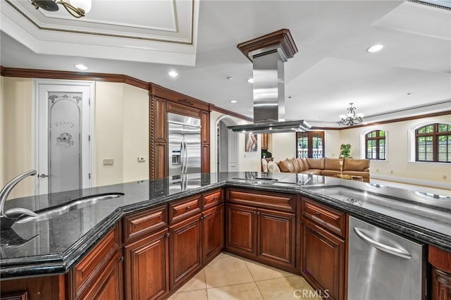 kitchen featuring stainless steel appliances, a wealth of natural light, dark stone counters, and an inviting chandelier