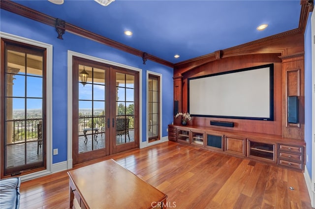 cinema featuring french doors, ornamental molding, and hardwood / wood-style flooring