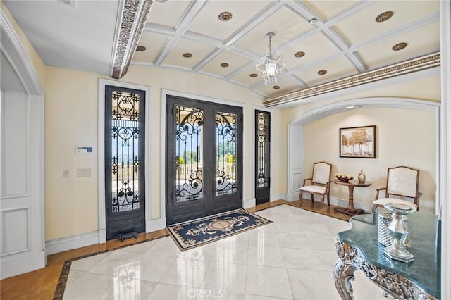 tiled foyer featuring french doors, beam ceiling, and coffered ceiling