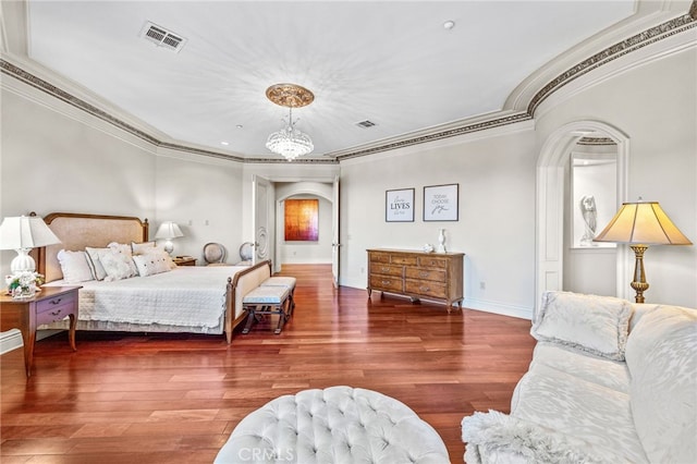 bedroom with crown molding, an inviting chandelier, and dark hardwood / wood-style floors