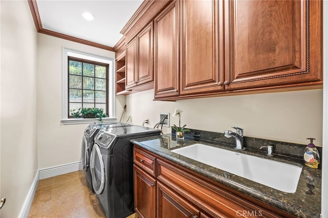 laundry area with ornamental molding, sink, washer and clothes dryer, and cabinets