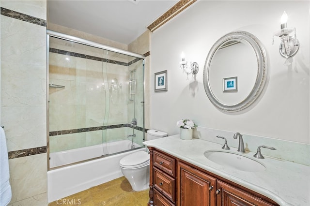 full bathroom featuring toilet, bath / shower combo with glass door, and vanity