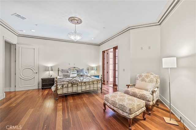 bedroom with crown molding, a chandelier, and hardwood / wood-style floors