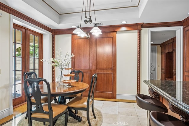 tiled dining room featuring french doors, ornamental molding, and a tray ceiling