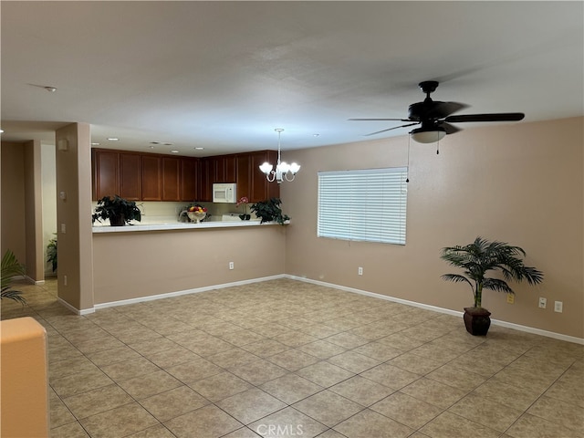 kitchen with kitchen peninsula, pendant lighting, and ceiling fan with notable chandelier