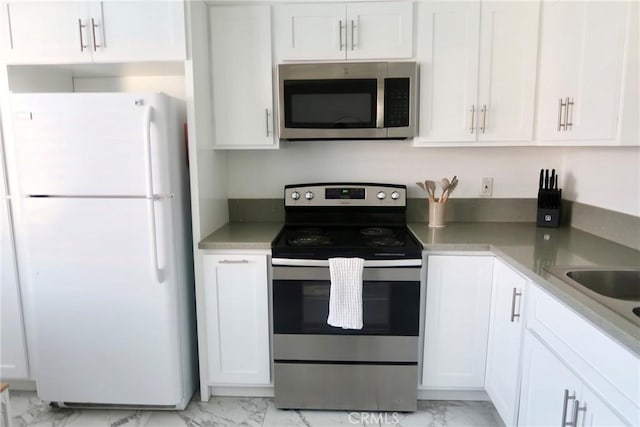 kitchen featuring sink, white cabinets, and appliances with stainless steel finishes