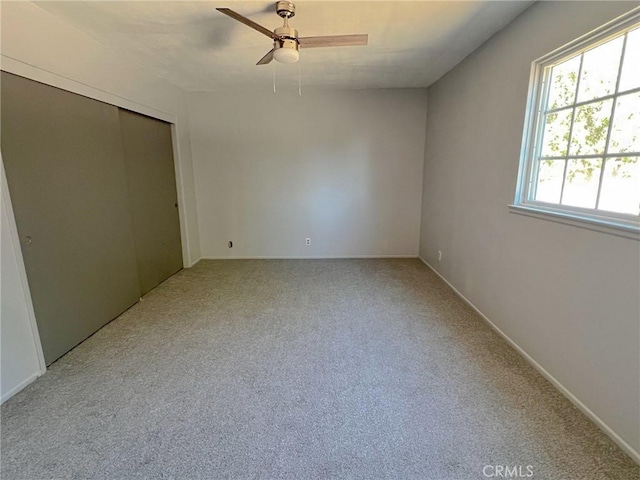 unfurnished bedroom featuring carpet flooring, ceiling fan, and a closet