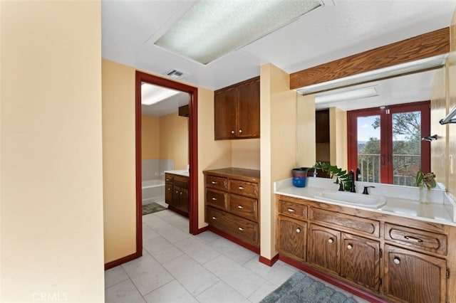 bathroom featuring tile patterned flooring, vanity, and french doors