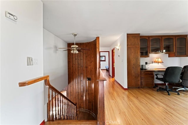 interior space featuring built in desk, hardwood / wood-style flooring, and ceiling fan