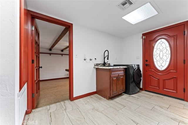 washroom with washer / clothes dryer, cabinets, and light hardwood / wood-style floors