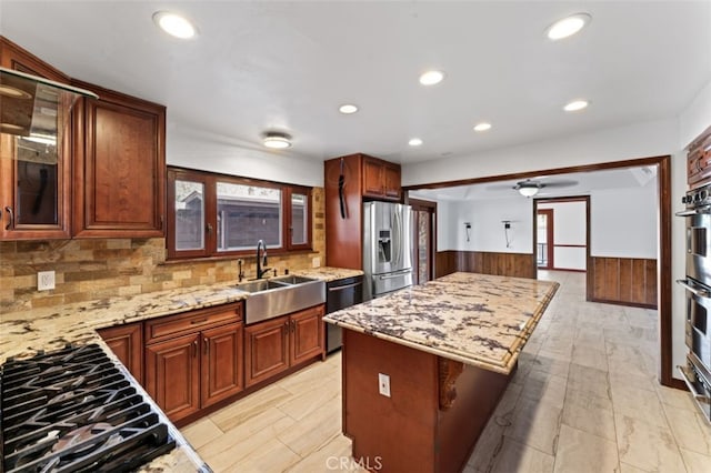 kitchen featuring sink, decorative backsplash, a kitchen island, a kitchen bar, and stainless steel appliances