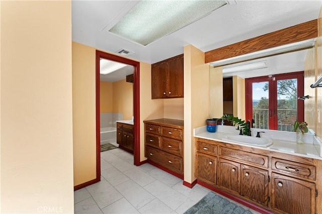 bathroom with tile patterned floors, vanity, and french doors