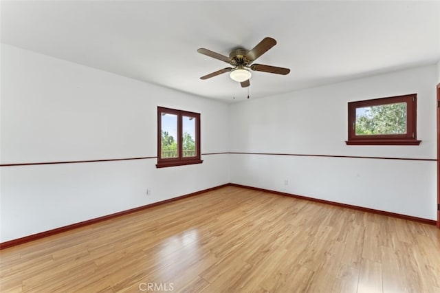 empty room with ceiling fan and light hardwood / wood-style flooring