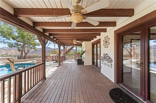 wooden deck with a fenced in pool, a mountain view, and ceiling fan