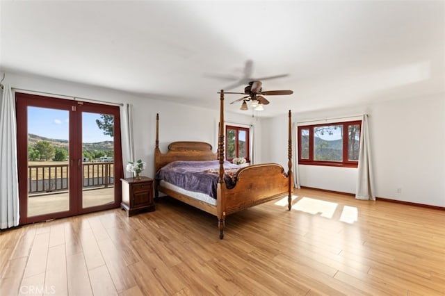 bedroom featuring access to exterior, light hardwood / wood-style flooring, and multiple windows