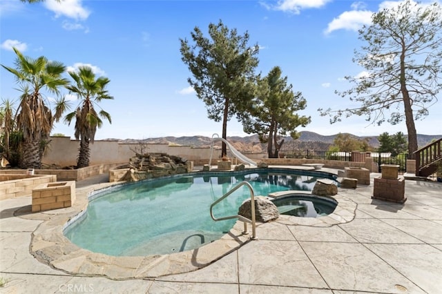 view of swimming pool with a mountain view, a patio area, an in ground hot tub, and a water slide