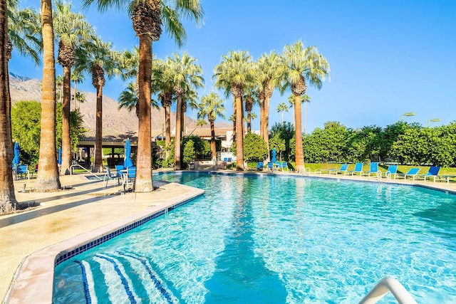 view of pool with a mountain view and a patio