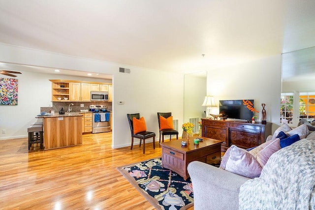 living room with sink and light hardwood / wood-style flooring