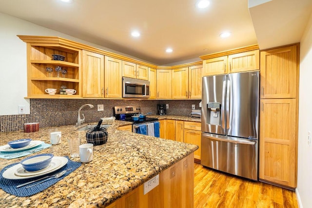 kitchen featuring light stone countertops, tasteful backsplash, stainless steel appliances, light brown cabinets, and light hardwood / wood-style floors