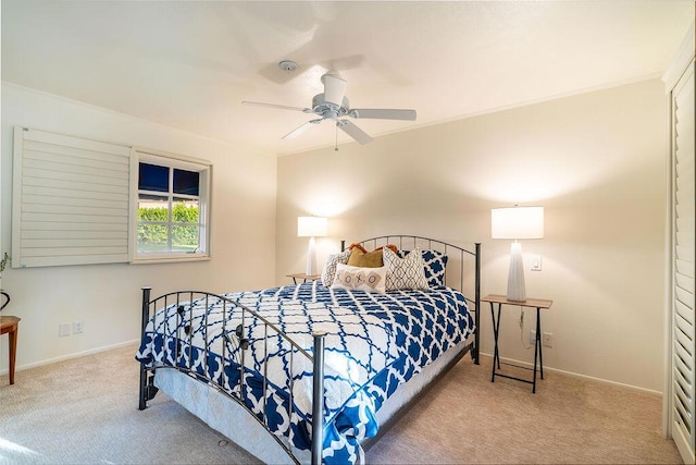 carpeted bedroom with ceiling fan and ornamental molding