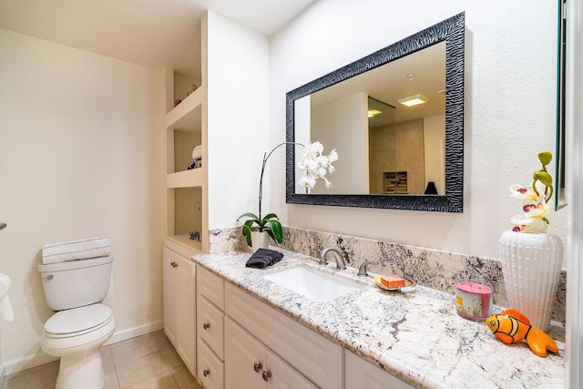 bathroom with tile patterned flooring, built in shelves, vanity, and toilet