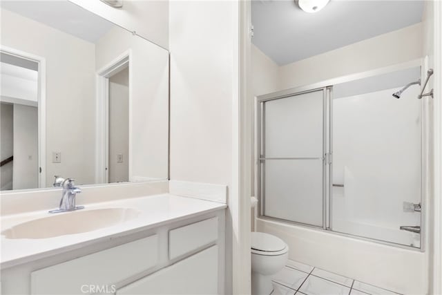 full bathroom with vanity, combined bath / shower with glass door, toilet, and tile patterned floors