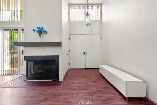 foyer entrance with dark wood-type flooring and a tile fireplace