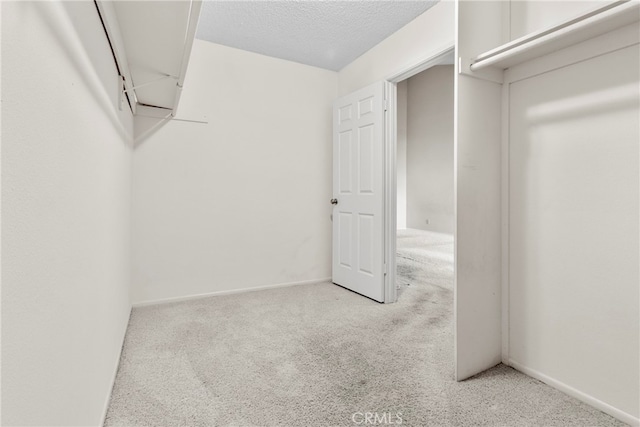 walk in closet featuring light colored carpet