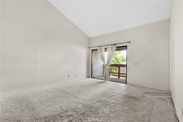 carpeted empty room with high vaulted ceiling