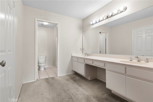 bathroom with vanity, a textured ceiling, toilet, and tile patterned flooring