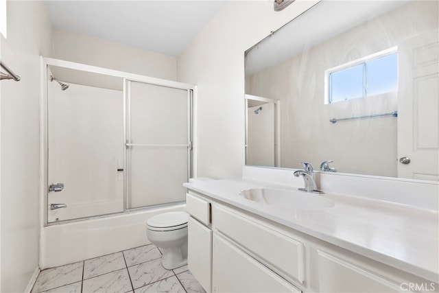 full bathroom featuring vanity, bath / shower combo with glass door, and toilet