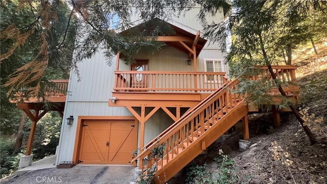 24861 Finhaut Dr, Crestline, CA 92325 - view of front of house featuring an attached garage, a wooden deck, stairs, and asphalt driveway