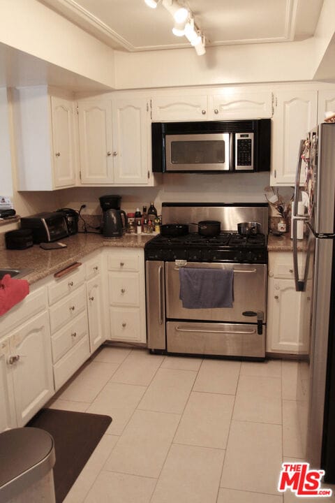 kitchen featuring white cabinets, light tile patterned flooring, and appliances with stainless steel finishes