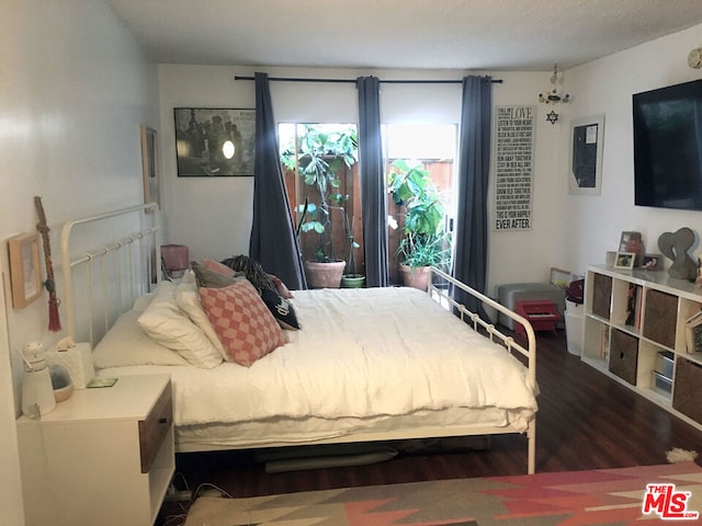 bedroom with dark wood-type flooring