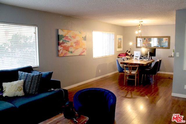 dining room featuring a chandelier, hardwood / wood-style floors, and a textured ceiling