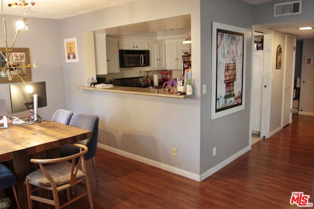 dining area with dark hardwood / wood-style flooring and a textured ceiling